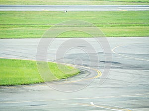 The stripes and curves of taxiway and green grass at the airport