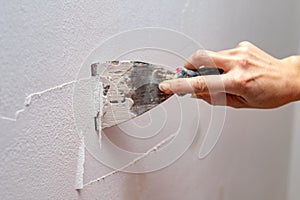 Stripping old paint from the wall. Renovation and painting of walls in the apartment