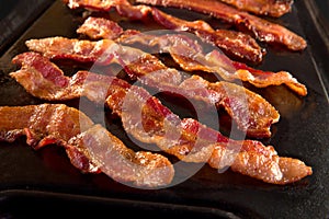 Strips of crispy bacon on cast iron pan photo