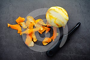 Strips of Orange Zest Next to a Whole Orange