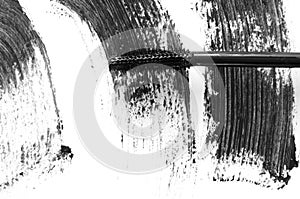 Stroke of black mascara with applicator brush close-up, isolated on white background.