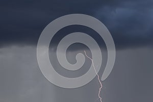 Stroke of lightning from dark thunderstorm cloud