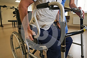 Stroke patient standing up with walking frame in hospital