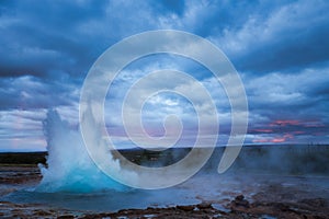 Strokkur Geysir Eruption with Dark Cloudy Sky, Iceland