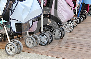 Strollers for toddlers parked on the parquet floor of wood