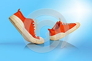 Strolling sports white-orange shoes over blue background. Sneakers or trainers isolated. Athletic shoes. fitness, sport