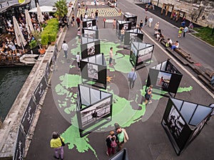 Strolling tourists view photo exhibit in the Berges du Seine, Paris