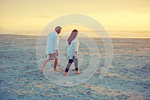 Strolls on the beach...no words needed. a mature couple going for a relaxing walk on the beach.