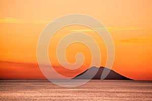 Stromboli active volcano against colorful sunset in Italy, view from Calabria coast