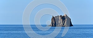 Strombolicchio, cliff with lighthouse, near Stromboli volcano, calm sea surface, Italy, Europe