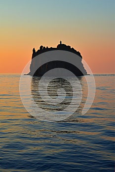 Strombolicchio with lighthouse, sunset at the island, Stromboli volcanoes, calm sea surface, Italy, Europe