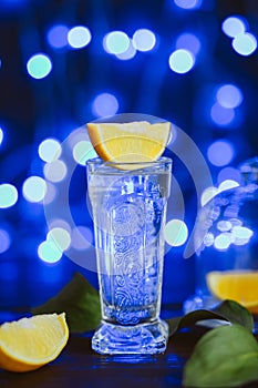Strong alcohol cocktail with lemon in jar glass on dark blue background. Studio shot of drink