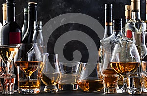 Strong alcohol drinks, hard liquors, spirits and distillates iset in glasses and bottles: cognac, scotch, whiskey and other. Black