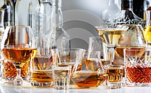 Strong alcohol drinks, hard liquors, spirits and distillates iset in glasses and bottles: cognac, scotch, whiskey and other. White