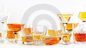 Strong alcohol drinks, hard liquors, spirits and distillates iset in glasses: cognac, scotch, whiskey and other. White background