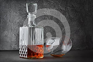 Strong alcoholic drink cognac in lying sniffer glass and crystal decanter