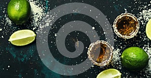 Strong alcoholic drink with salt and lime, dark background, top