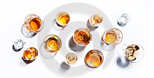 Strong alcoholic drinks, hard liquors, spirits and distillates in glasses: vodka, cognac, whiskey and other. White background.