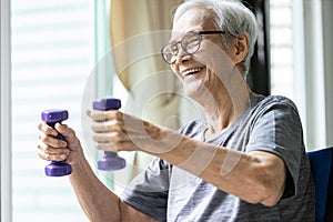 Strong asian senior woman working out,lifting dumbbell weights for strength training,old elderly using dumbbells while exercising,