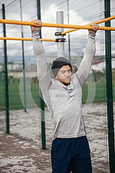 Strong athlete does a pull-up on the crossbar.