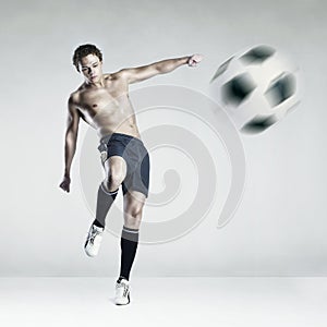 Strong athlete kicking the ball