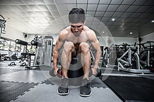 Strong Athletic Asian Man workout with dumbbell curl Concentration muscle on shoulder abd back for bodybuilding