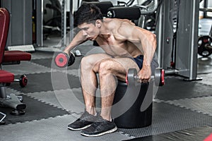 Strong Athletic Asian Man workout with dumbbell curl Concentration muscle on shoulder abd back for bodybuilding photo