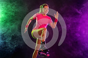 A Strong athletic, female runner on the black bacground wearing a tight, fitness outfit. Sports girl in shoes for kangoo
