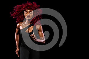 A strong athletic afro american woman on black background wearing in sportswear, fitness and sport motivation. Sport