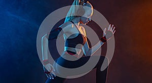 Strong athletic fit woman on black with neon lights background wearing in the sportswear. Fitness and sport motivation.