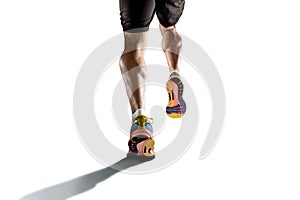 Strong athletic legs with ripped calf muscle of young sport man running isolated on white background