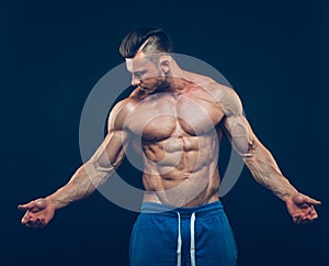 Strong athletic man on black background