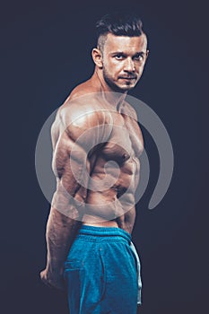 Strong athletic man on black background