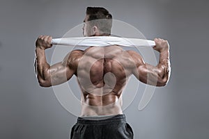 Strong Athletic Man Fitness Model posing back muscles, triceps,