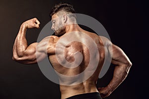 Strong Athletic Man Fitness Model posing back muscles, triceps,