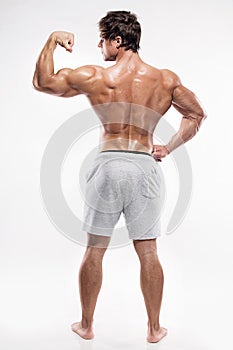 Strong Athletic Man Fitness Model posing back muscles, triceps,