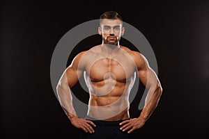 Strong Athletic Man - Fitness Model showing his Torso with six pack abs. isolated on black background with copyspace