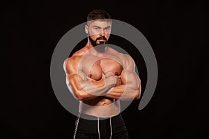 Strong Athletic Man Fitness Model Torso showing six pack abs. isolated on black background with copyspace