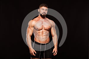 Strong Athletic Man Fitness Model Torso showing six pack abs. isolated on black background with copyspace