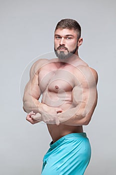 Strong Athletic Man Fitness Model Torso showing six pack abs. isolated on grey background with copyspace