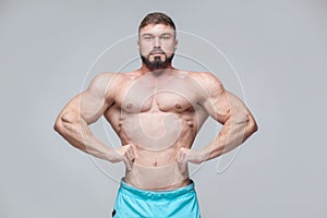 Strong Athletic Man Fitness Model Torso showing six pack abs. isolated on grey background with copyspace