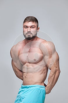 Strong Athletic Man Fitness Model Torso showing six pack abs. isolated on grey background with copyspace