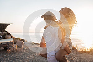 Strong athletic man holding his appealing woman on his hands