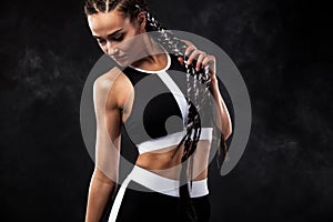 A strong athletic woman on black background wearing in black fashion sportswear, fitness and sport motivation. Sport