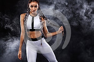 A strong athletic woman on black background wearing in white sportswear, fitness and sport motivation. Sport concept