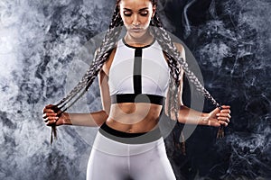 A strong athletic woman on black background wearing in white sportswear, fitness and sport motivation. Sport concept