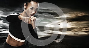 A strong athletic, woman boxer, boxing at training on the sky background. Sport boxing Concept with copy space.