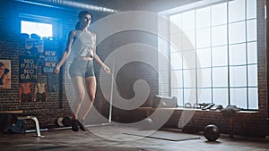 Strong Athletic Woman Exercises with Jumping Rope in a Loft Style Industrial Gym. She& x27;s