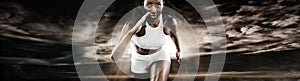 Strong athletic woman sprinter, running on dark background wearing in sportswear. Fitness and sport motivation. Runner