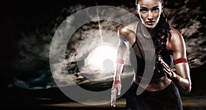 Strong athletic woman sprinter, running on dark background wearing in sportswear. Fitness and sport motivation. Runner